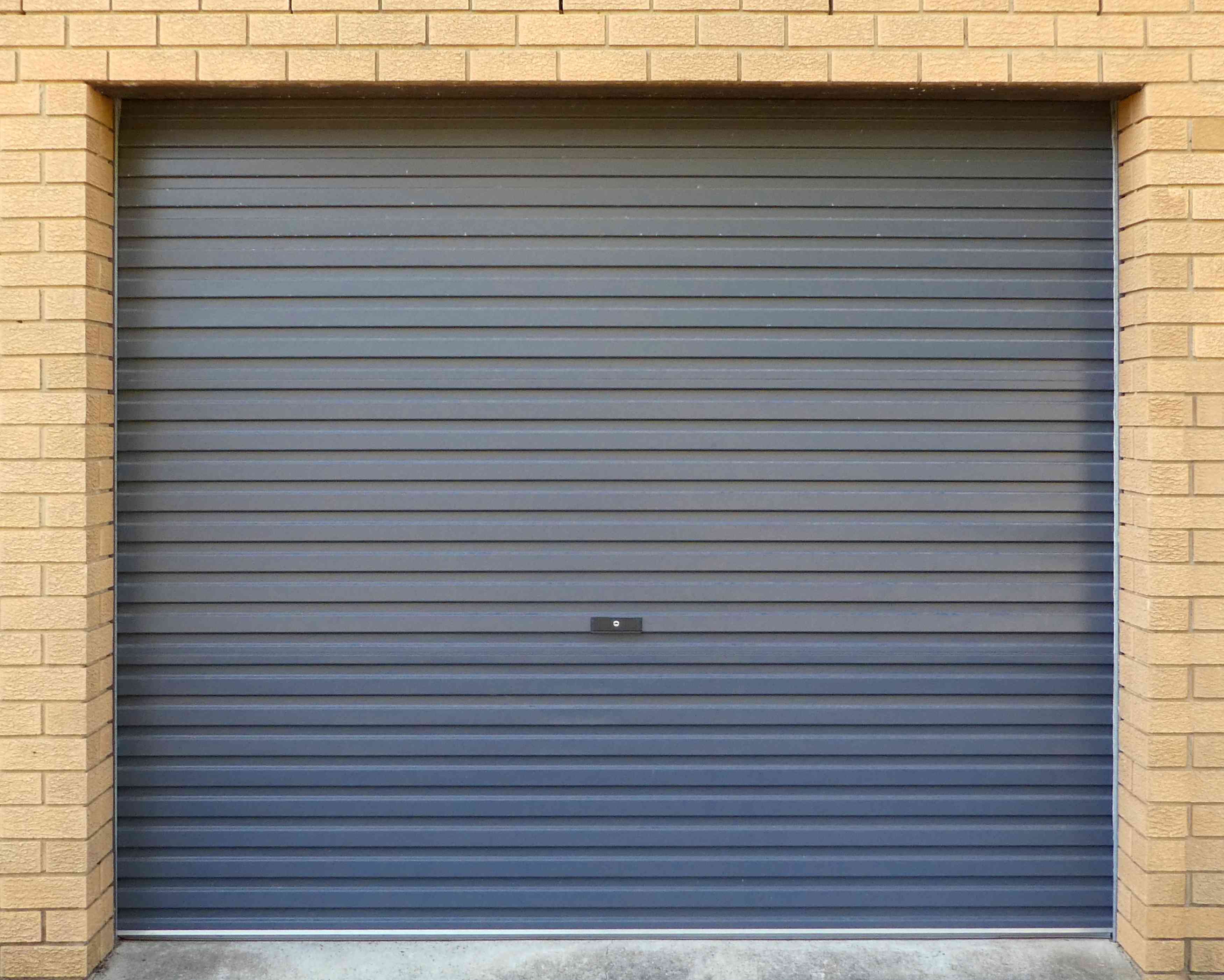 garage-door-grey-corrugated-metal-on-blonde-brick--3J8X6FF(1)(1) Noisy Garage Door? Here’s What It Means